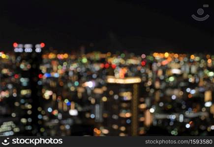 Colorful blurred aerial downtown skyscrapers with city bokeh lights background illuminated at night