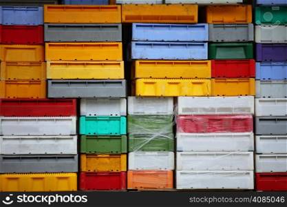 colorful boxes plastic crates background. Packing containers piles for fish storage of catch.