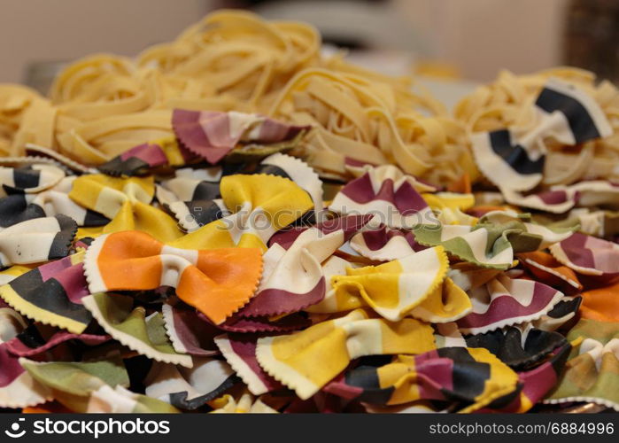 Colorful Butterfly Uncooked Italian Pasta and Tagliatelle Pasta in Background