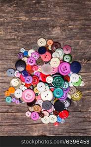 Colorful buttons heap on a wooden background. Colorful buttons heap