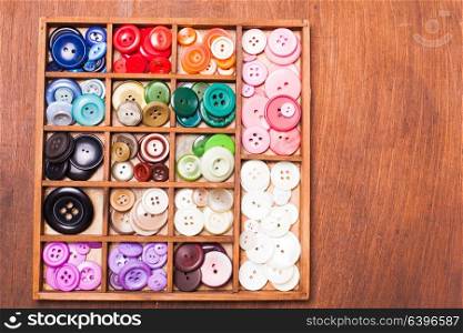 Colorful buttons in a wooden box for design. Colorful buttons in box