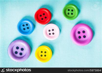 Colorful buttons on the blue textile close up. The Colorful buttons