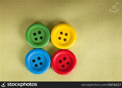 Colorful buttons on the green textile close up. The Colorful buttons