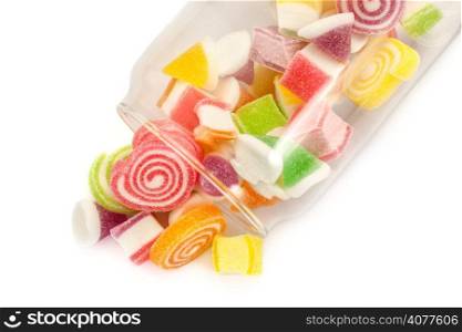 Colorful candies in bottle on white background