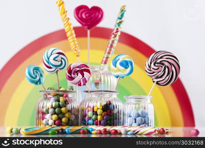 Colorful candies in jars on table on gum balls. Glass jars in Colorful candies,lollipops and gum balls