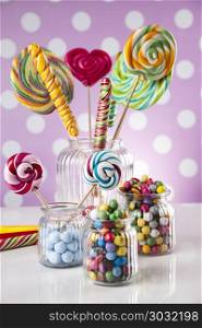 Colorful candies in jars on table on gum balls. Glass jars in Colorful candies,lollipops and gum balls