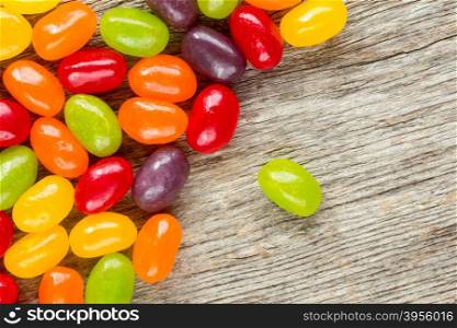 Colorful candies on wooden background with copy-space