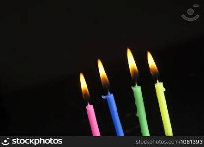 Colorful candles burning in the dark