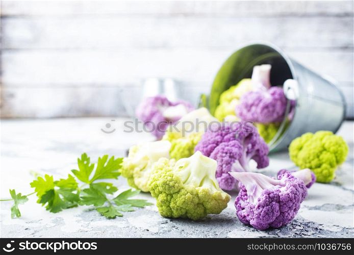 Colorful cauliflower cabbages on gray background. Healthy food