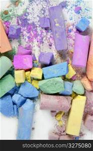 Colorful chalk broken colors mess over white background