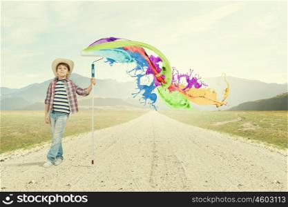 Colorful childhood. Boy of school age painting wall with brush
