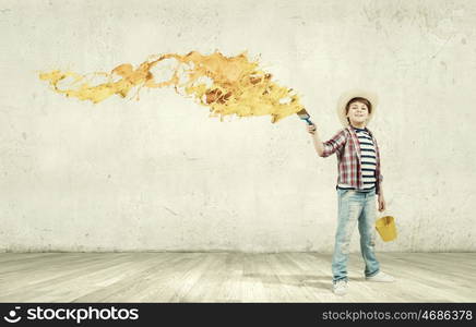 Colorful childhood. Boy of school age painting wall with brush