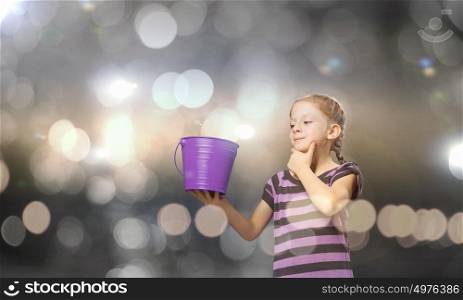 Colorful childhood!. Cute girl with bucket against bokeh background