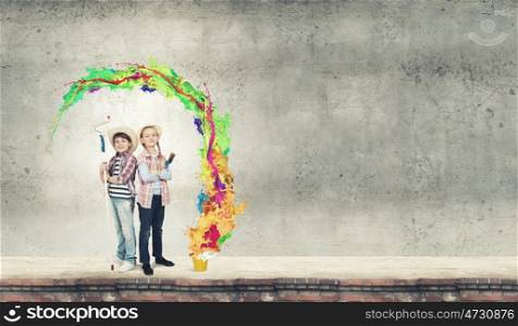 Colorful childhood. Two children of school age painting wall with roller