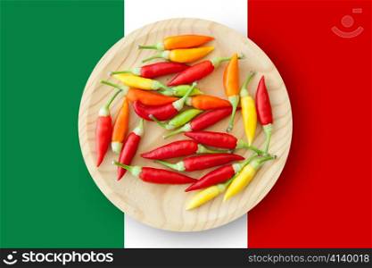 colorful chili peppers plate with Mexico flag in background