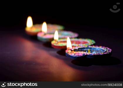 Colorful clay Diya  Lantern  l&s lit during Diwali celebration. Greetings Card Design Indian Hindu Light Festival called Diwali.