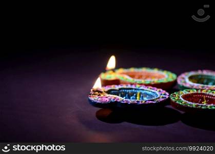Colorful clay Diya  Lantern  l&s lit during Diwali celebration. Greetings Card Design Indian Hindu Light Festival called Diwali.