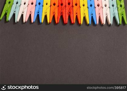 Colorful clothespins on black background