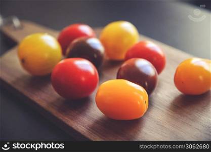 Colorful cocktail tomatoes on a wooden cutting board. Cocktail tomatoes on a cutting board