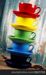 Colorful coffee cups on wooden table over blue background