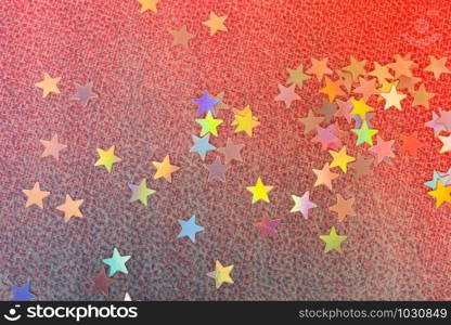 Colorful confetti stars on a gold colorful background