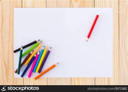 Colorful crayons on a sheet of lined white paper.