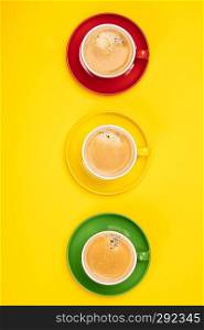 Colorful cups of coffee on yellow background, flat lay. Colorful cups of coffee on yellow background