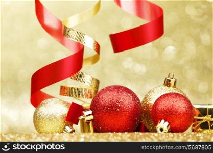 Colorful decorative curling ribbons and balls over glitter background