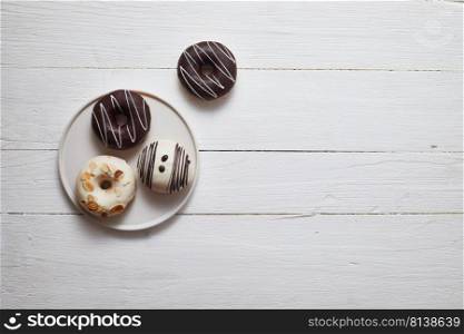 Colorful donuts on wooden tab≤. Top view with©space. 
