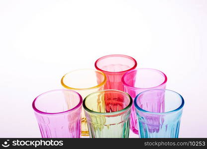 Colorful drinking glasses on white background