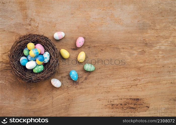 Colorful Easter Egg and nest on a rustic old wood background. Above view with copy space.