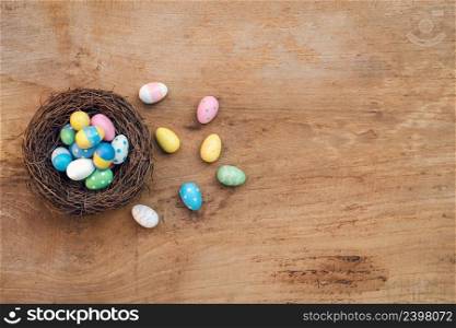 Colorful Easter Egg and nest on a rustic old wood background. Above view with copy space.