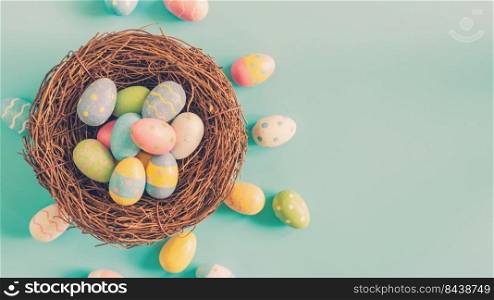 Colorful easter egg and nest on green pastel color background with space.