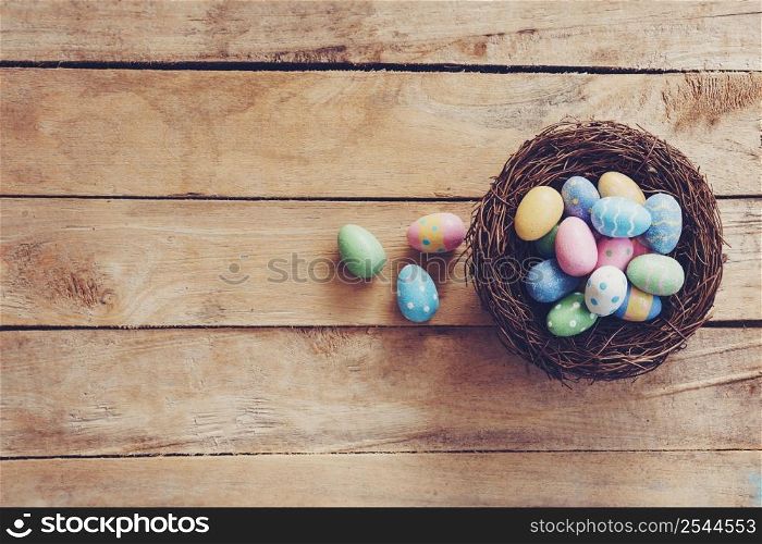 Colorful Easter egg and nest on wooden table background with copy space.
