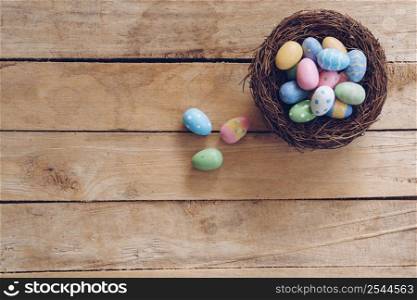 Colorful Easter egg and nest on wooden table background with copy space.