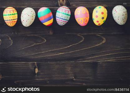 Colorful easter egg on wood background with space