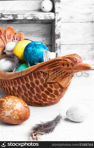 colorful Easter eggs. Easter colored egg in a wooden symbolic chicken.