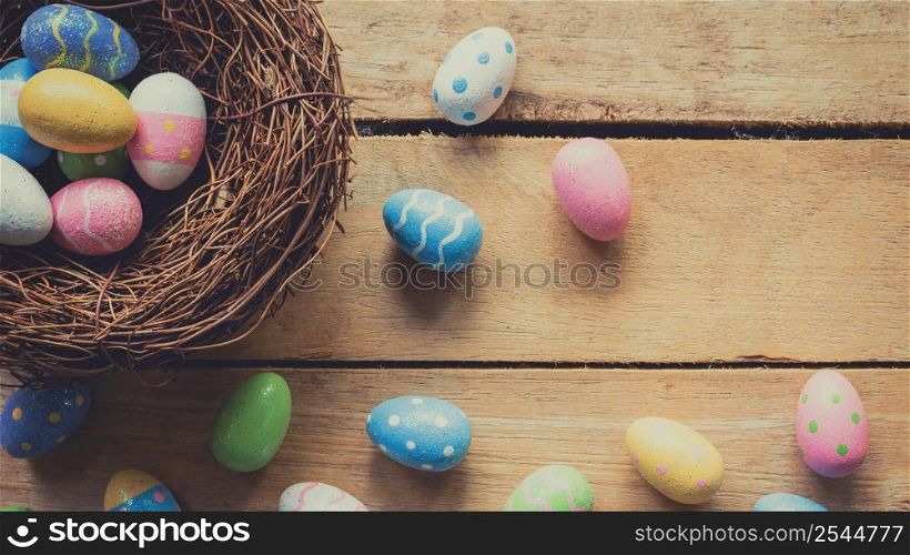 Colorful easter eggs in neat on plank wooden background with space.