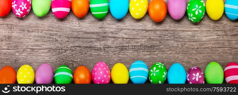 Colorful easter eggs on old brown wooden board card banner with copy space for text. Easter egg on wooden board