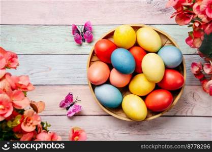 Colorful Easter eggs on pink background with flowers. Top view. Easter eggs on pink background with flowers
