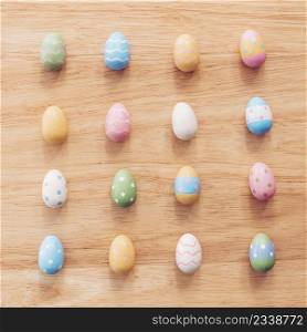 Colorful easter eggs on wooden table background with vintage toned.