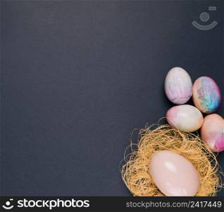 colorful easter eggs pink egg nest corner black backdrop