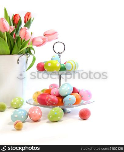 Colorful easter eggs with pink tulips on white background