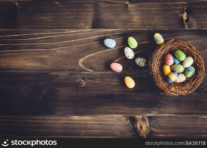 Colorful eggs easter in the nest on wood background with copyspace.