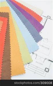 Colorful fabric sample with an architectural drawing paper on designer desk