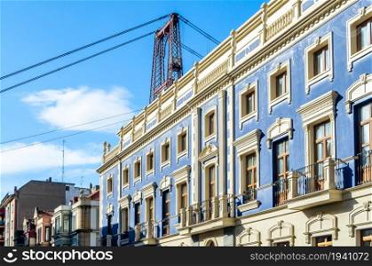 Colorful facades in the old town of Portugalete, Spain, with the famous Vizcaya Bridge in the background