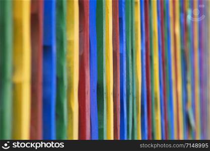 Colorful fence made of painted sticks. Colored sticks background