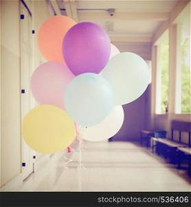 Colorful festive balloons decorated in hallway with retro filter effect
