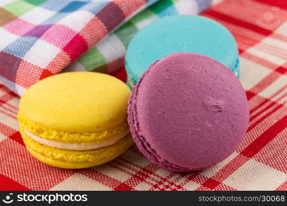 Colorful few macaroons on tablecloth fabrick close up