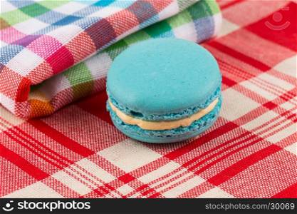 Colorful few macaroons on tablecloth fabrick close up